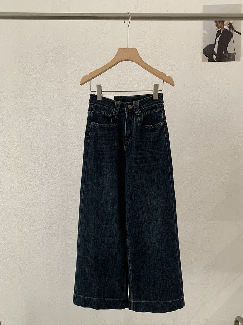 Jean bleu foncé, taille haute, coupe ample et amincissante.