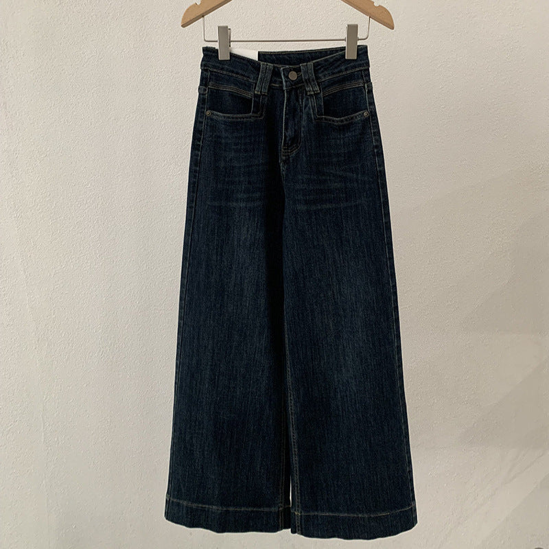 Jean bleu foncé, taille haute, coupe ample et amincissante.