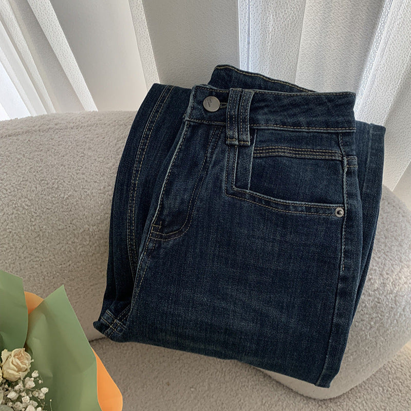 Jean bleu foncé, taille haute, coupe ample et amincissante.