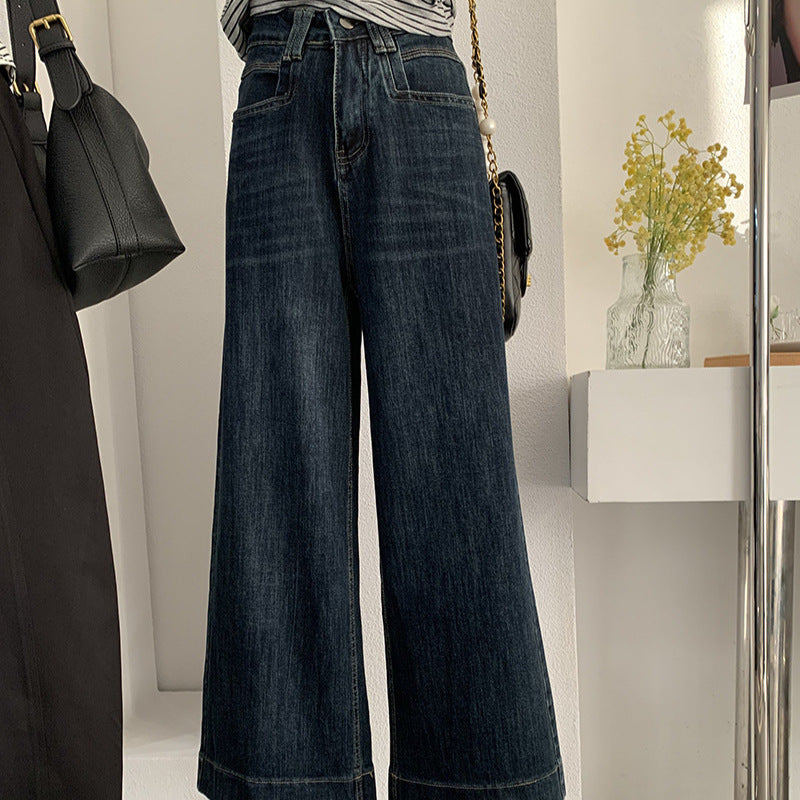 Jean bleu foncé, taille haute, coupe ample et amincissante.